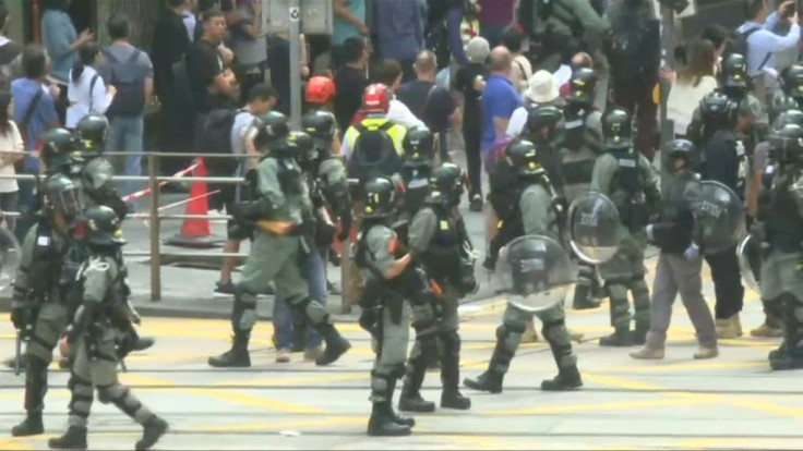 IMAGESHong Kong riot police arrive in the city's Central district where thousands of office workers have taken time out during their lunch break to support the pro-democracy protest movement.