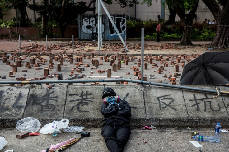 A Hong Kong pro-democracy protester sleeps on a barricaded street outside a university