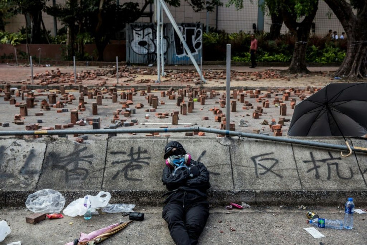 A Hong Kong pro-democracy protester sleeps on a barricaded street outside a university
