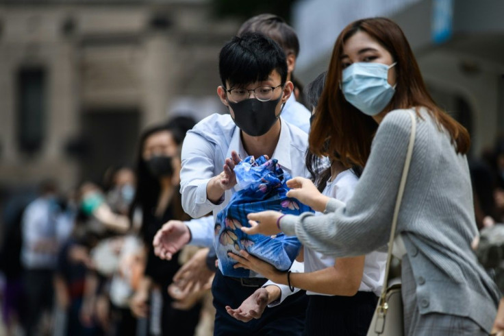 Hong Kong office workers deploy the tactics of street protest - including the formation of two lines creating a channel to pass supplies