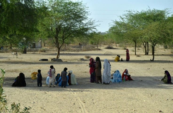 Pakistani villagers sit under trees on a hot summer day in Sindh province in May 2018