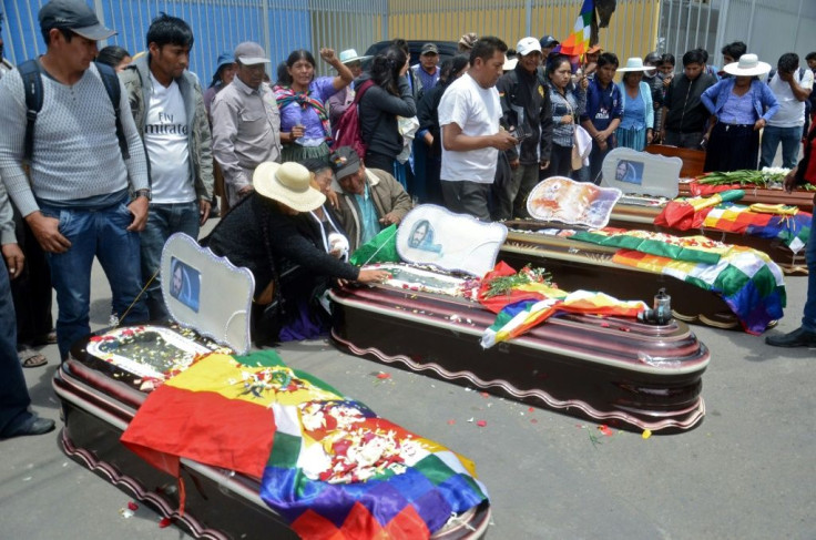 Relatives mourn by the coffins of protesters killed during protests in the Bolivian town of Sacaba on November 16, 2019