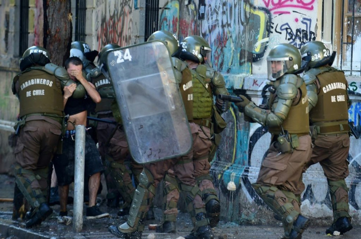 Riot policemen arrest a demonstrator during a protest against the government in Santiago on November 16, 2019