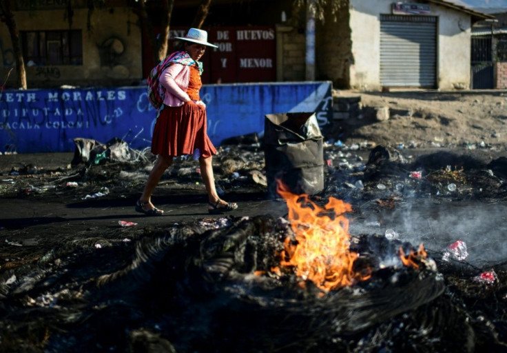 An indigenous woman walks through a blockade -- erected by supporters of Bolivian ex-President Evo Morales -- in the outskirts of Sacaba near Cochabamba