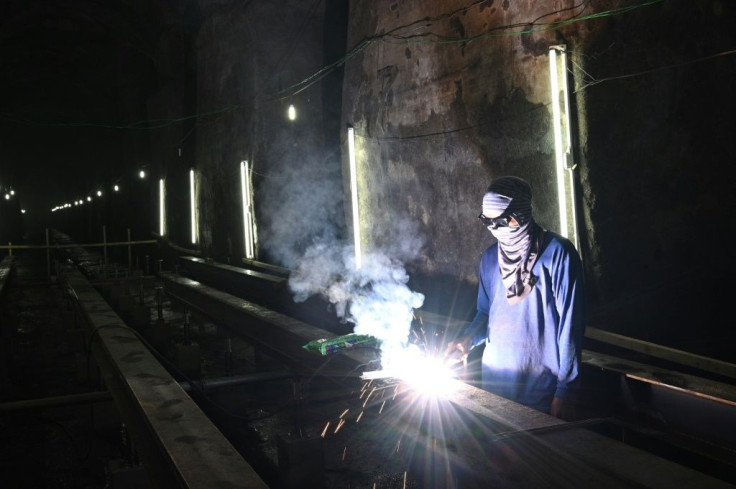 A worker welds a metal pathway at the site