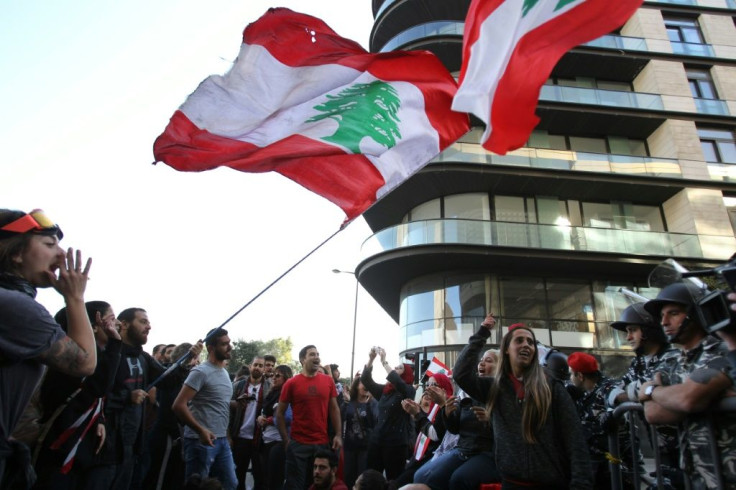 Lebanese anti-government protesters mass in front of a barrier near parliament in the capital Beirut
