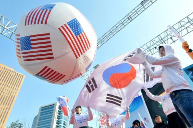 South Korean conservative activists roll a large balloon showing the US flags by a South Korean flag during a rally to support South Korea-US free trade agreement in Seoul in 2012