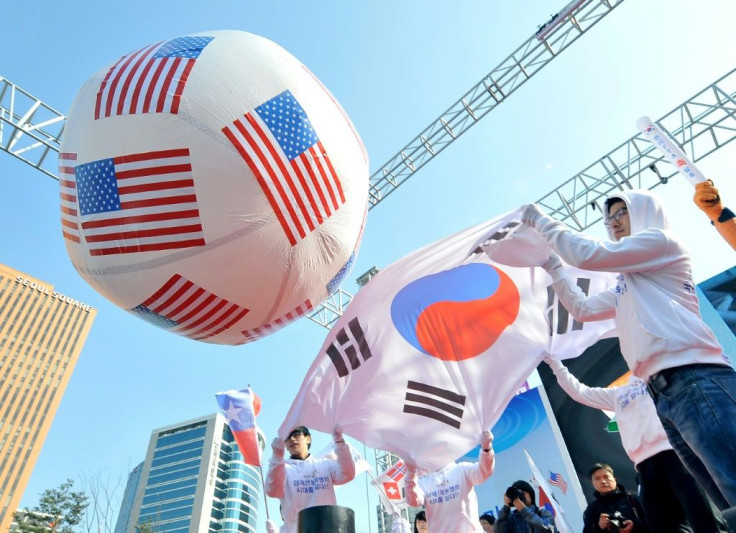 South Korean conservative activists roll a large balloon showing the US flags by a South Korean flag during a rally to support South Korea-US free trade agreement in Seoul in 2012