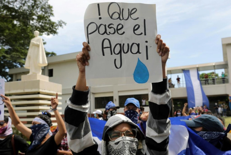 A student carries a sign reading "Let the water pass" during a protest of students and relatives of political prisoners, in Managua on Tuesday