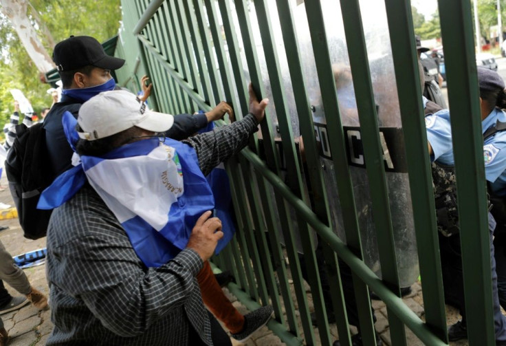 Students, friends and relatives of political prisoners protest in front of a police line at Managua's Central American University