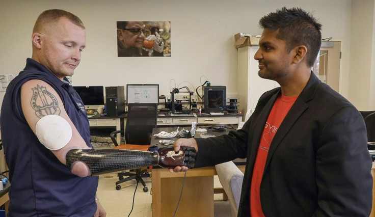 The new technology could allow the retired veteran to simultaneously clasp the hands of his two children