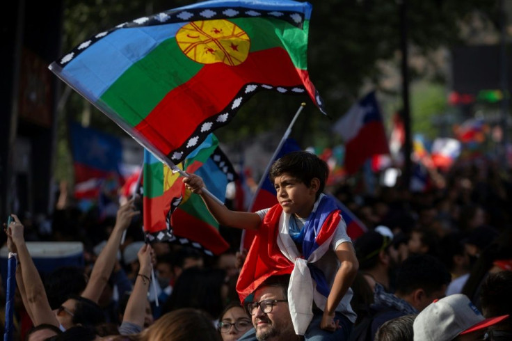 A child holds a Mapuche indigenous flag during a march in Santiago on November 01