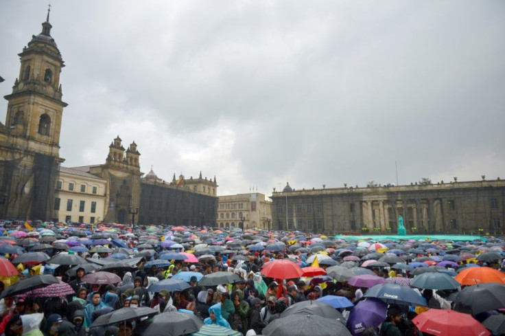 People demonstrate under pouring rain at Bolivar square in Bogota during a general strike to protest government policies