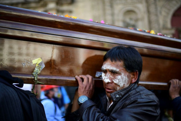 A man carries the coffin of a slain supporter of former president Evo Morales, before riot police fired tear gas to break up the massive funeral procession that turned into an anti-government demonstration