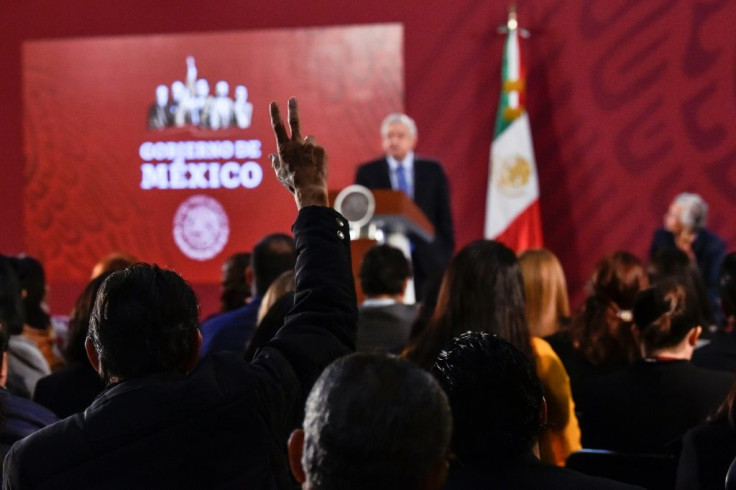 A reporter raises his hand to ask a question during Mexican President Andres Manuel Lopez Obrador's daily morning press conference at the National Palace in Mexico City on November 21, 2019