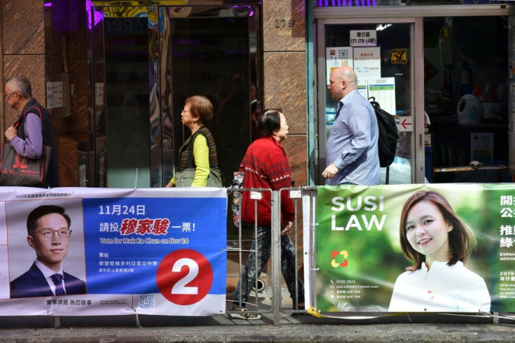 Pedestrians walk past campaign banners for Sunday's election