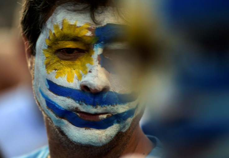 A supporter of Uruguay's presidential candidate Luis Lacalle Pou, with his face painted in the colors of Uruguay's flag, attends the candidate's final campaign rally
