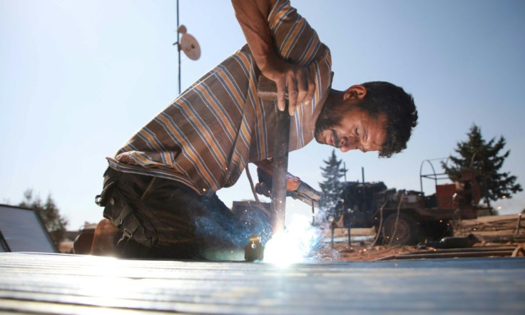 Jumaa al-Mustayf welds metal pipes for another tent frame