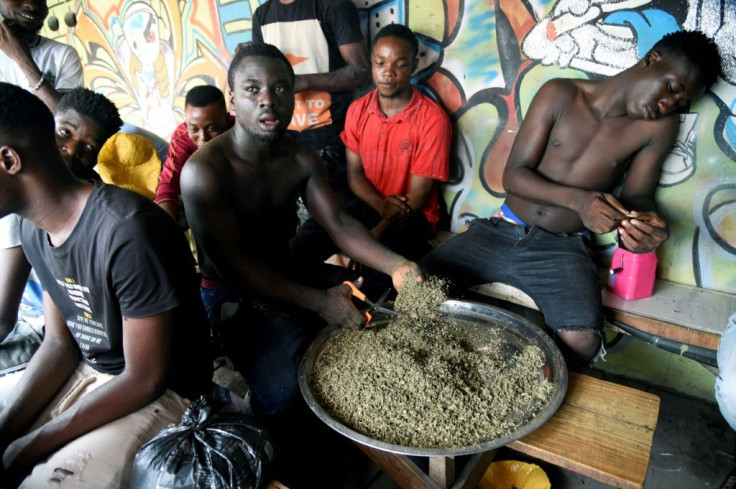 A vendor cuts marijuana for sale in Lagos