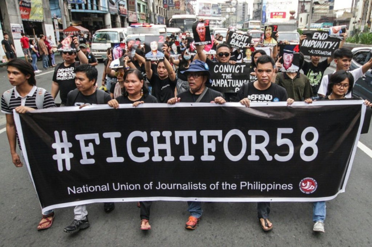 Journalists take part in a protest outside the presidential palace in Manila to commemorate the tenth anniversary of the Philippines' worst political massacre where 58 people, including 32 media workers, were slaughtered and dumped in roadside pits