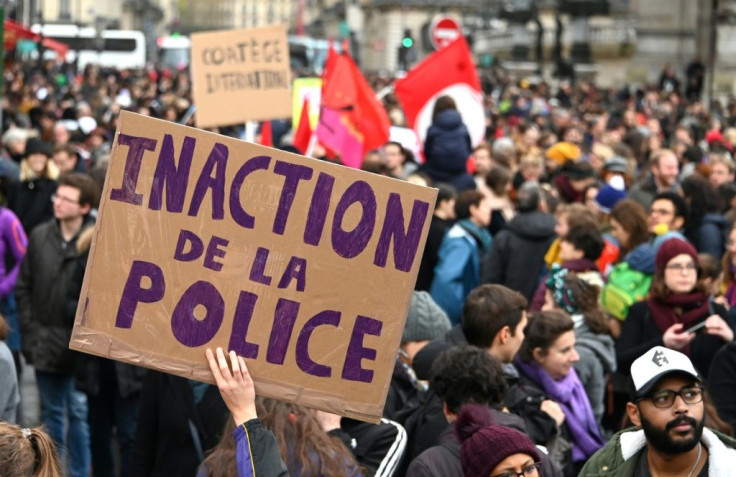 A person holds up a placard reading "Police inaction"