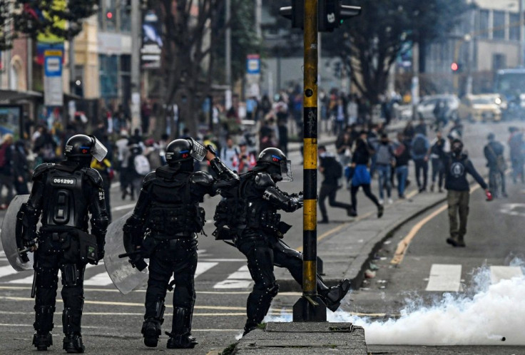 A riot policeman kicks a tear-gas canister during an anti-government protest in Bogota on November 23, 2019