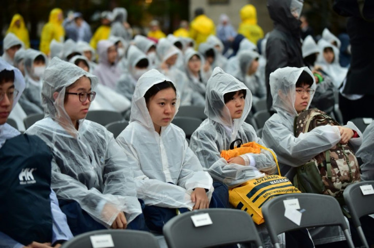 Hundreds of people in white waterproofs stood in torrential rain to hear the pope's speech