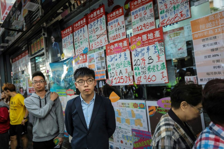 Pro-democracy activist Joshua Wong, who was disqualified from running, queues up to cast his vote during district council elections in Hong Kong