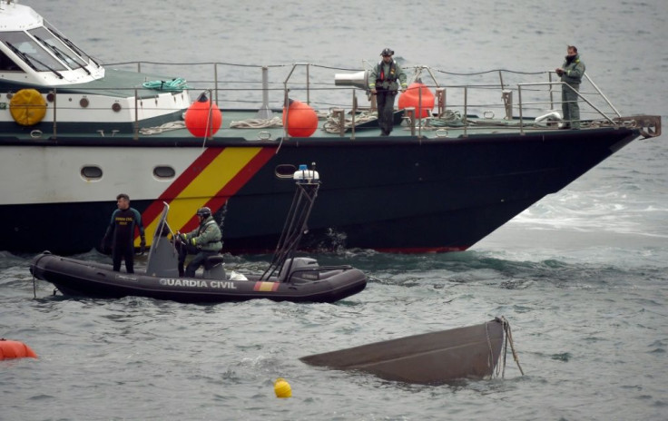 The prow of a submarine used to transport drugs illegally emerges as Spanish Guardia Civil's divers work to refloat it in northwestern Spain
