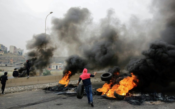 Lebanese anti-government protesters burn tyres as they block a road in the northern city of Tripoli on November 25, 2019