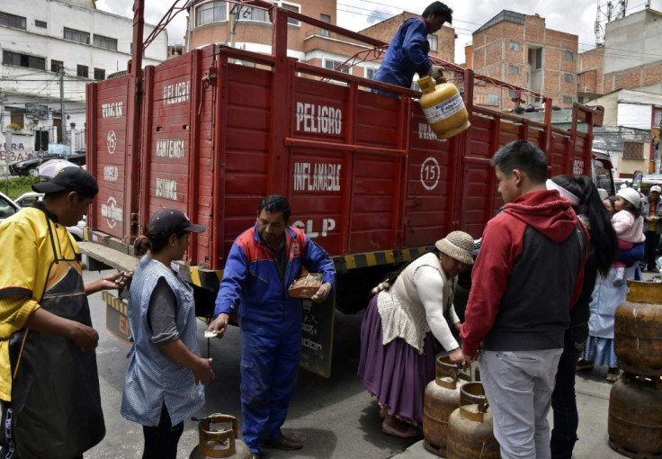 A man downloads gas cylinders from a truck in La Paz as life gets back to normal after weeks of protests