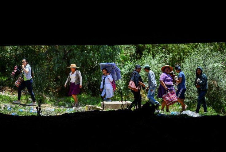 A group of people walk under a bridge blocked by followers of former Bolivian president Evo Morales in Sacaba on November 20, 2019
