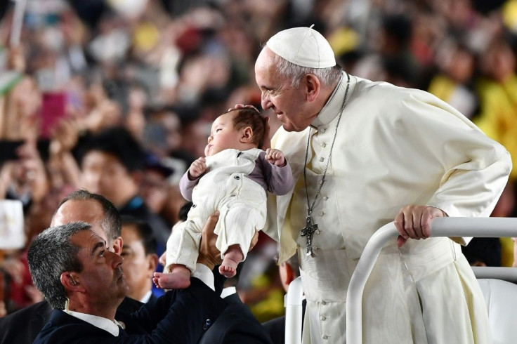 Pope Francis kissed a stream of babies passed up to him