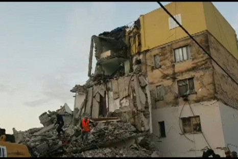 Emergency services and people clear the debris of a collapsed building