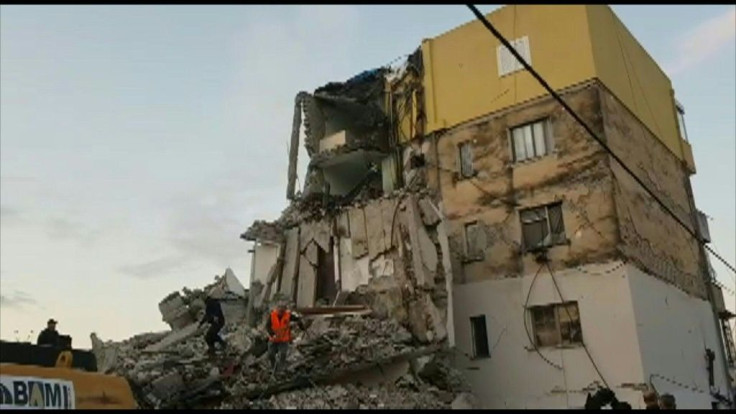 Emergency services and people clear the debris of a collapsed building