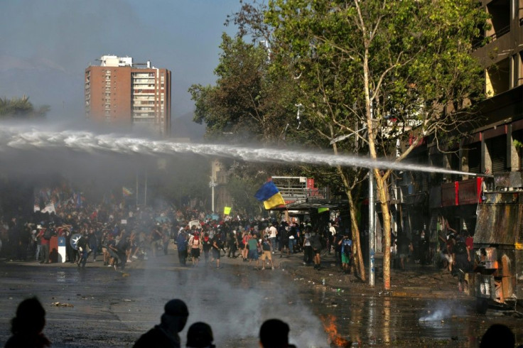 Riot police deployed water cannons in an attempt to control anti-government demonstrations in Santiago