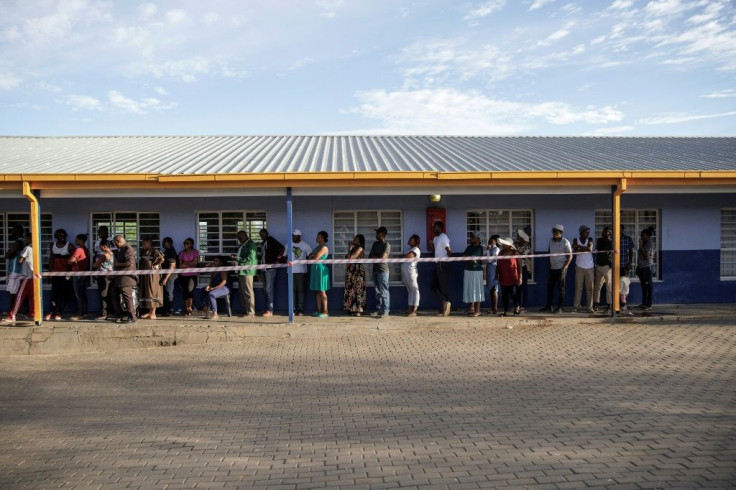 Voters shelter from the scorching sun waiting to cast their ballots at a polling station in the capital Windhoek