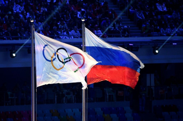 This file photo taken on February 23, 2014 shows the Olympic flag and the Russian flag flying during the Closing Ceremony of the Sochi Winter Olympics