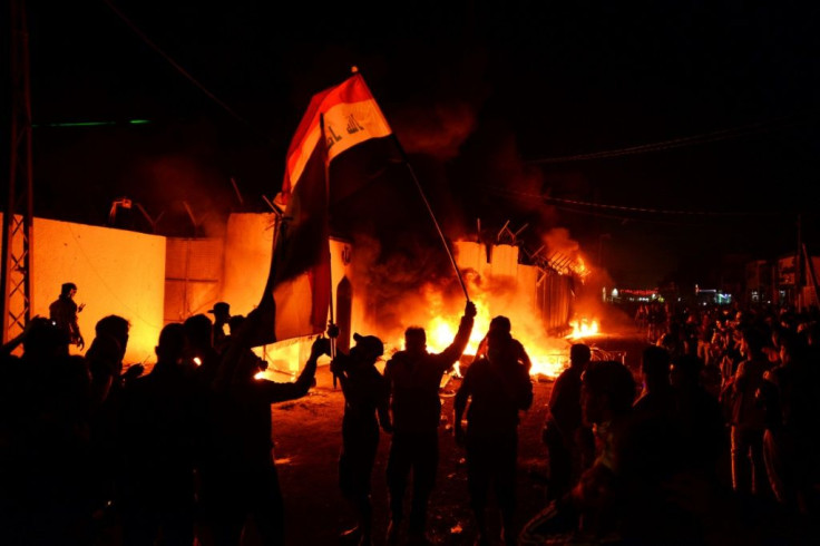 Iraqi demonstrators gather as flames start consuming Iran's consulate in the southern Iraqi Shiite holy city of Najaf on November 27, 2019