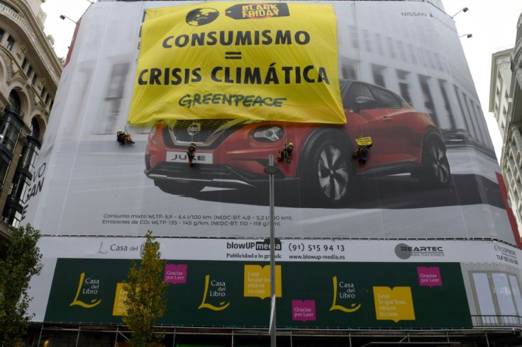 Greenpeace activists on Friday unfurled a banner on the Gran Via, a main shopping artery in the Spanish capital, which read "Consumerism = Climate Crisis."