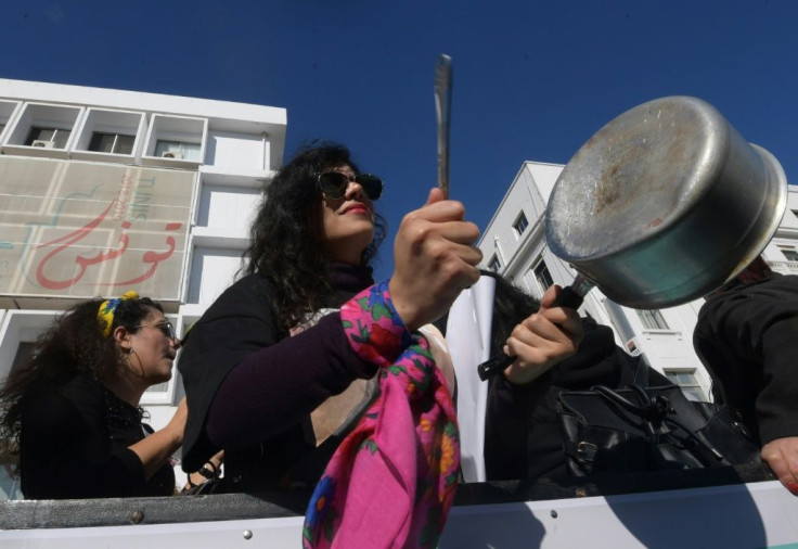 A member of the Tunisian "EnaZeda", (Me too) movement bangs a pot at a rally against sexual harassment in Tunis on November 30, 2019