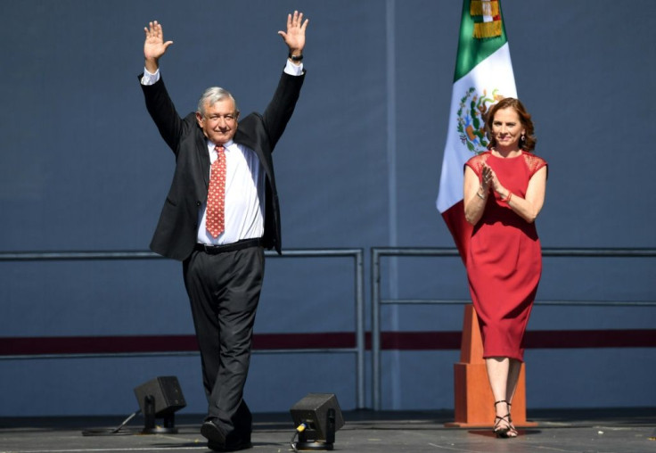 Mexican President Andres Manuel Lopez Obrador (left) waves next to his wife Beatriz Gutierrez Muller during a rally marking his first year in office at the Zocalo square in Mexico City on December 1, 2019