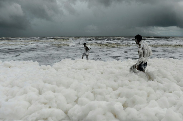 Children have been playing and taking selfies in the clouds of white suds on Marina Beach, even though they give off an acrid smell and fishermen have been told not to go into the sea nearby