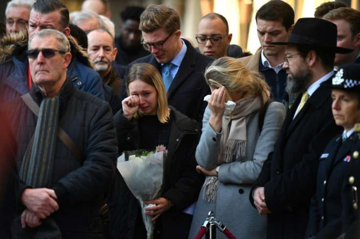 Members of the public cry at a vigil in central London