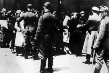 SS soldiers lead newly arrived prisoners to the gas chambers at the Auschwitz concentration camp. The death camp remains an enduring symbol of the Holocaust.