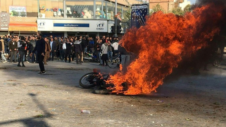 Iranian protesters gather around a burning motorcycle in the city of Isfahan during a demonstration last month against an increase in fuel prices