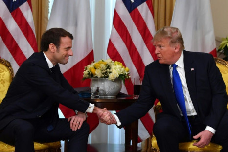 US President Donald Trump (R) shakes hands with French President Emmanuel Macron met before the NATO summit