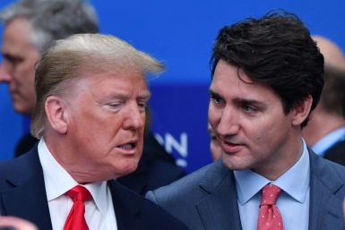 US President Donald Trump (L) talks with Canada's Prime Minister Justin Trudeau during the plenary session of the NATO summit