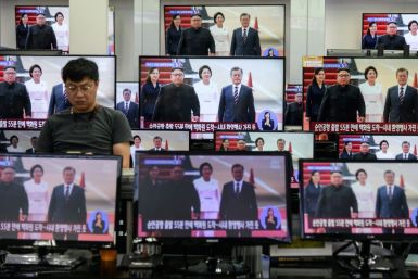 South Korean President Moon Jae-in (right on screens) met three times with the North's leader Kim Jong Un last year