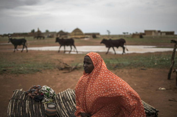 The long trail: Safira, a nomadic herder, sits on a straw mat outside her family hut in a Fulani camp in Dosso
